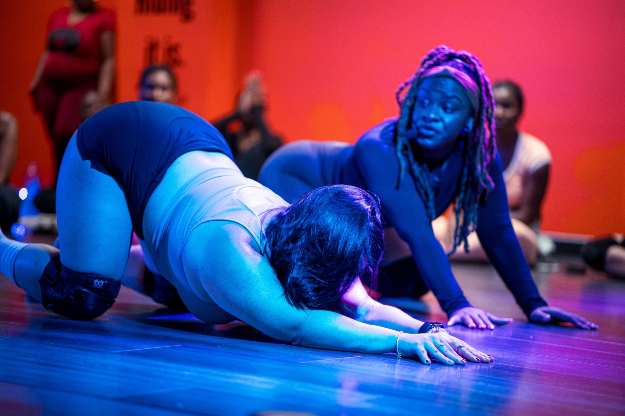 Coco guiding a participant through movement during a class