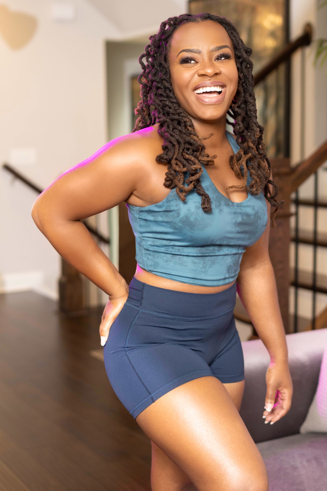 Coco smiling in a teal movement outfit