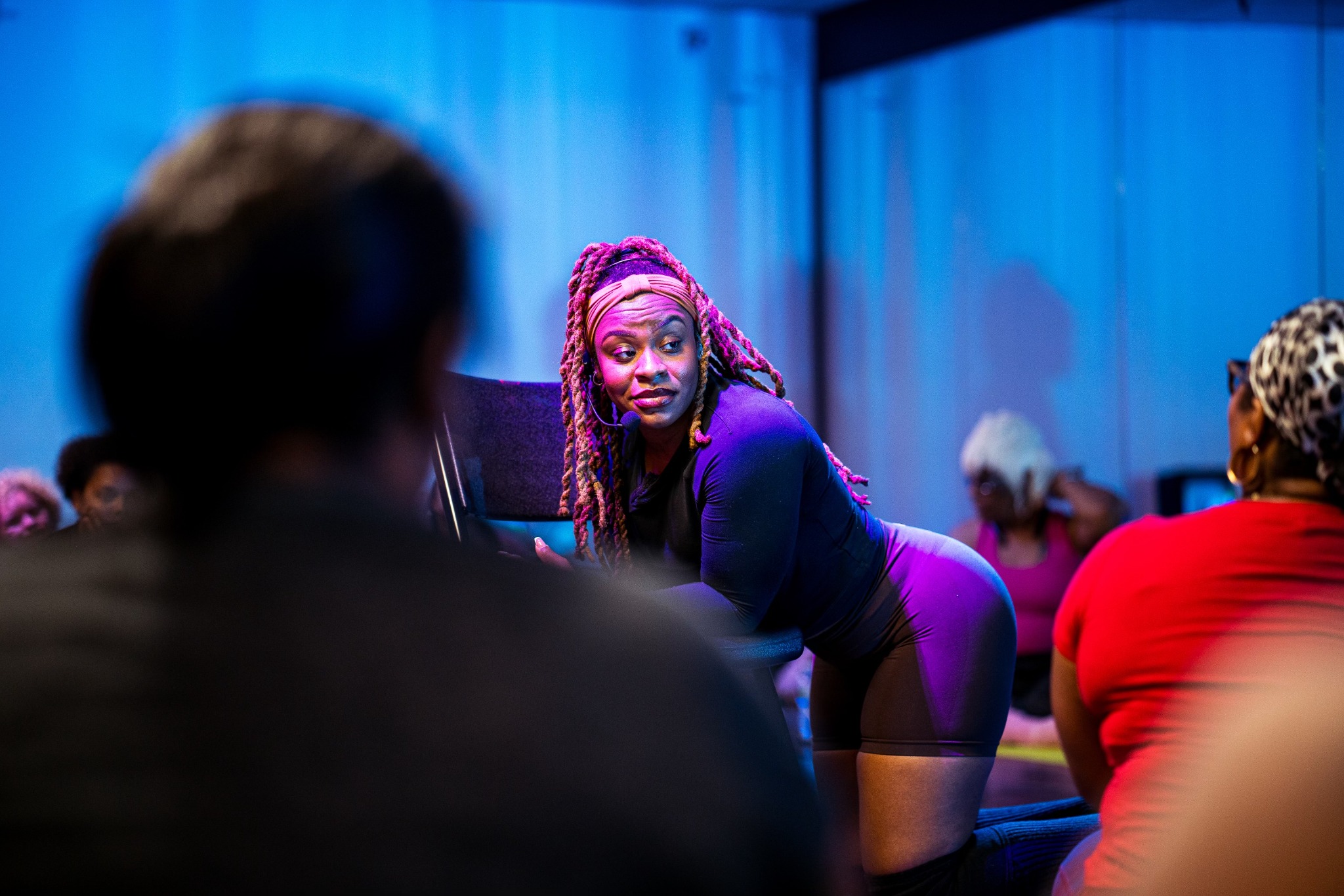 Coco coaching a participant in a movement class; image represents the experience, not a confirmed Atlanta event